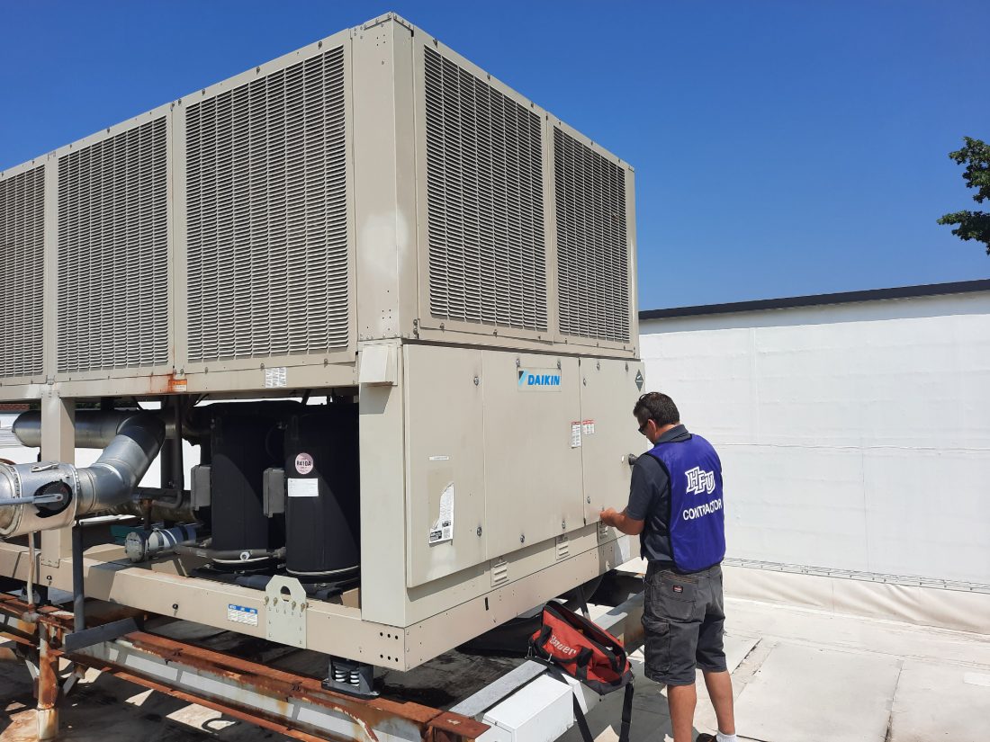 An SBS-NC employed technician servicing a rooftop chiller — self-performed, not subcontracted