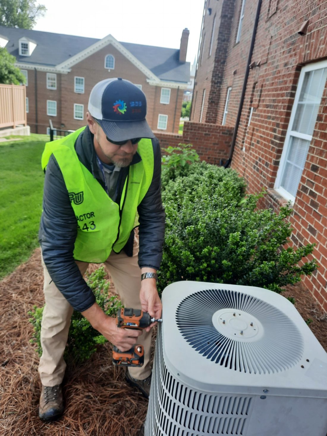 An SBS-NC technician performing scheduled preventative maintenance on a commercial condensing unit at High Point University